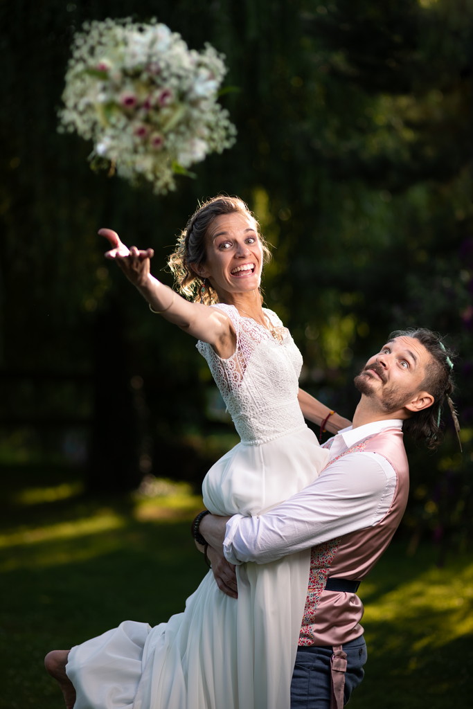 Jeté de bouquet par la mariée portée par son mari