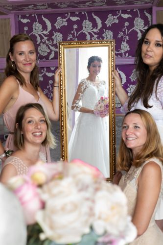 Mariée dans le miroir entourée de ses amies