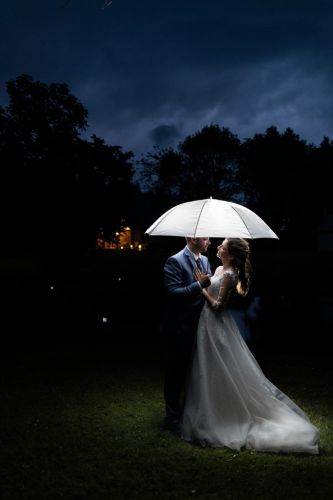 Mariés sous un parapluie qui semble les éclairer