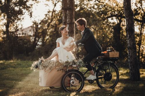 Photo des mariés à vélo dans un décor très naturel