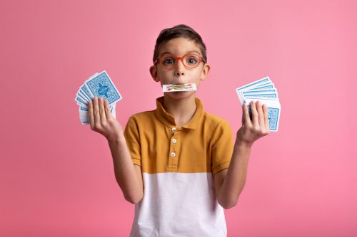 Portrait créatif d'un enfant qui fait des tours avec des cartes