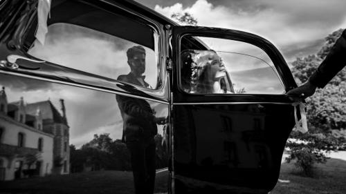 Mariés et leur voiture, photo de mariage originale en noir et blanc