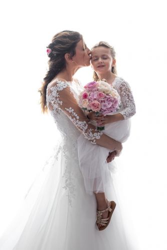 Mariée et sa fille en blanc avec le bouquet
