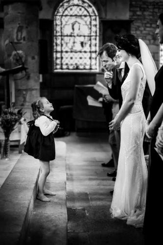 Petite fille devant les mariés à l'église, en noir et blanc