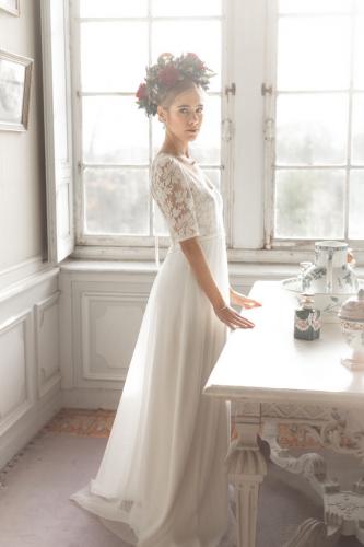 Mariée posant avec sa robe blanche et sa couronne de fleurs