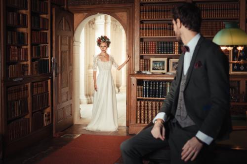 La mariée en robe de mariage découvre son futur mari dans son costume