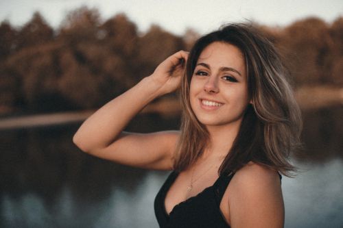 Portrait de jeune femme souriante près d'un lac